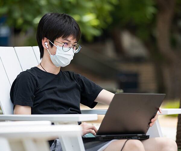 a man wearing eyeglasses working on a laptop